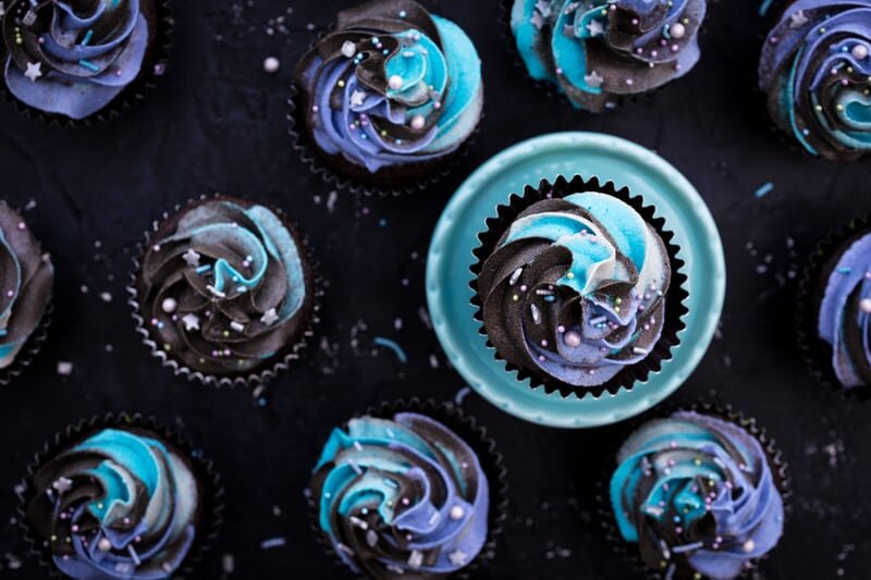 dark cupcakes with swirled galaxy frosting.