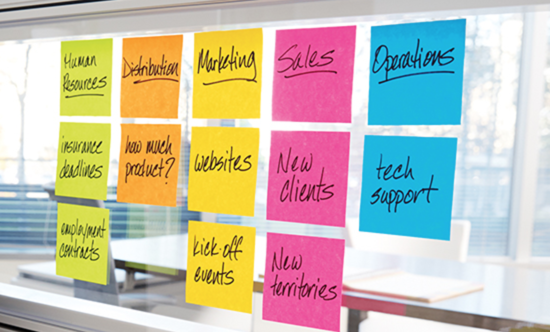 post it notes sorted by colour in columns on a window.