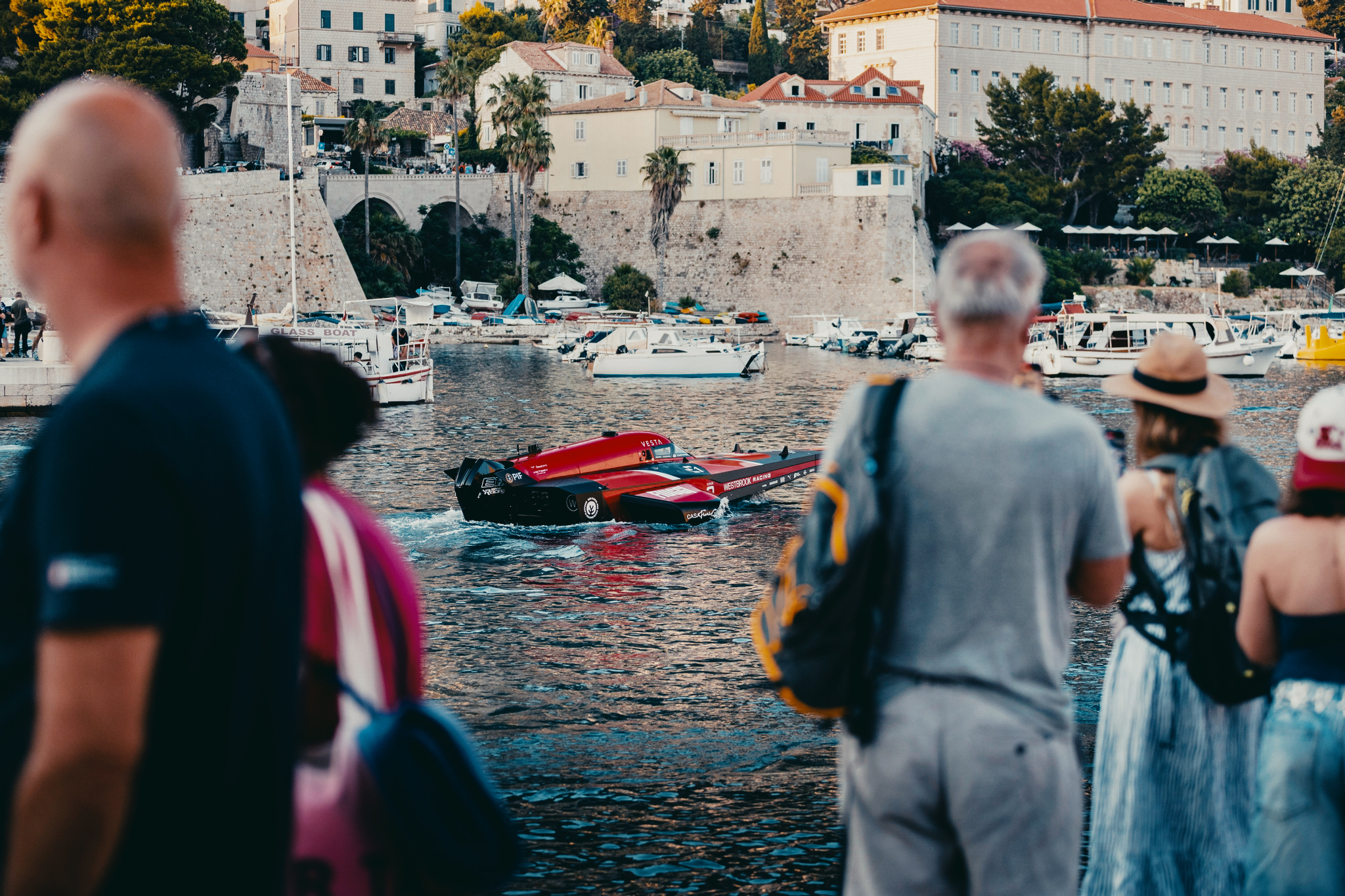 An electric power boat from E1 Series 2025, visible through a crowd of spectators.