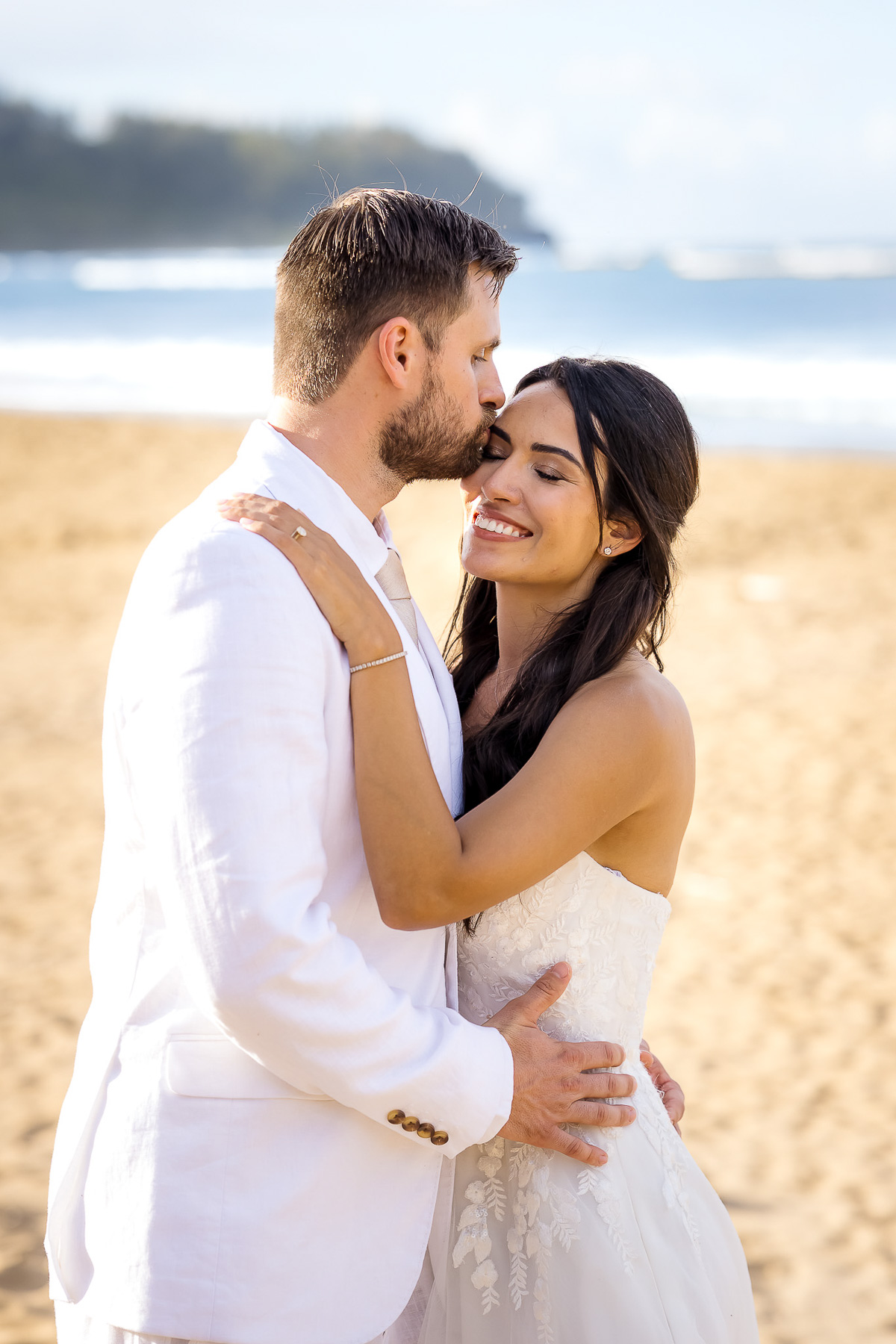 Groom kissing his bride during a Hanalei Bay Kauai elopement, photographed by a Kauai wedding photographer.