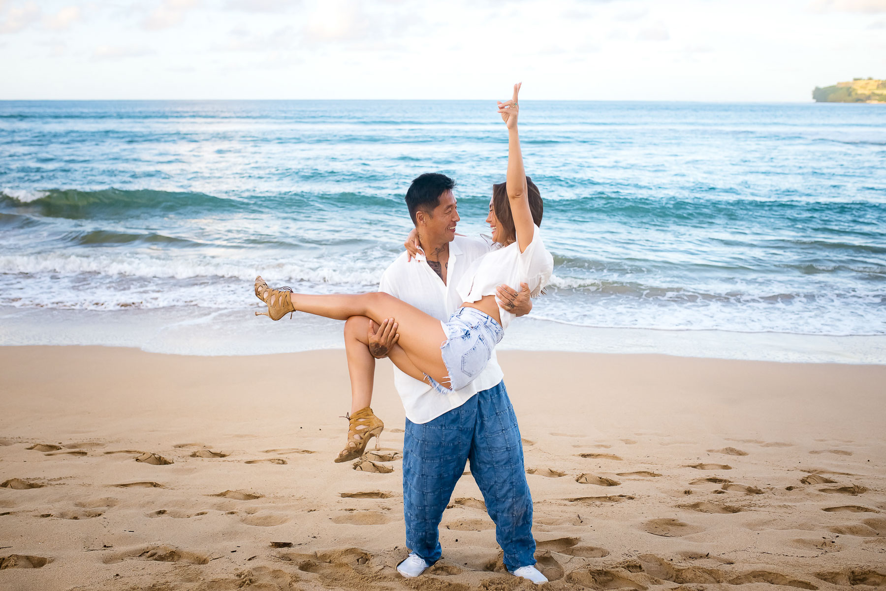 Man holding up his fiancee in his arms