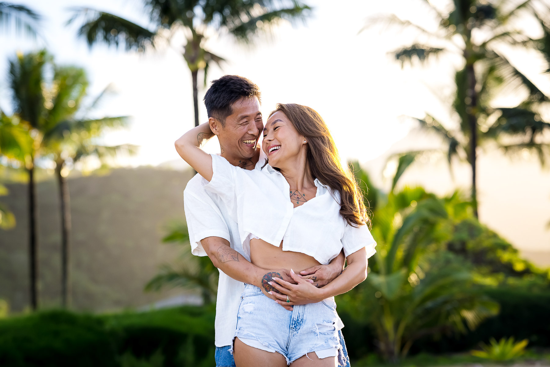 Man making his fiance smile as he hugs her.