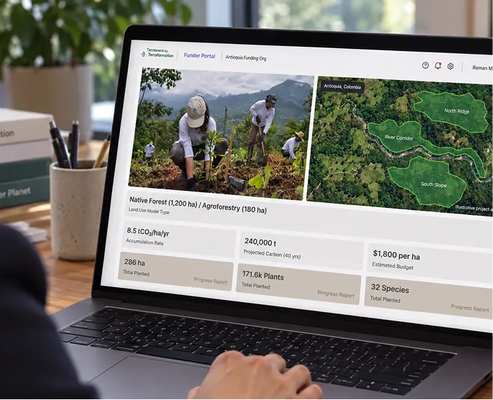 Laptop screen showing a Terraformation project dashboard with images of people planting trees and a map highlighting areas labeled North Ridge, River Corridor, and South Slope in Antioquia, Colombia, along with data on native forest and agroforestry land use including carbon accumulation, projected carbon over 40 years, budget, hectares planted, plants planted, and species planted.