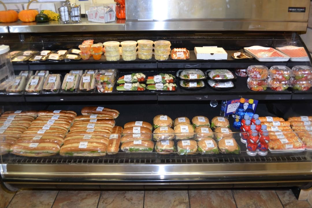 Deli shelf with sandwiches, salads, and drinks