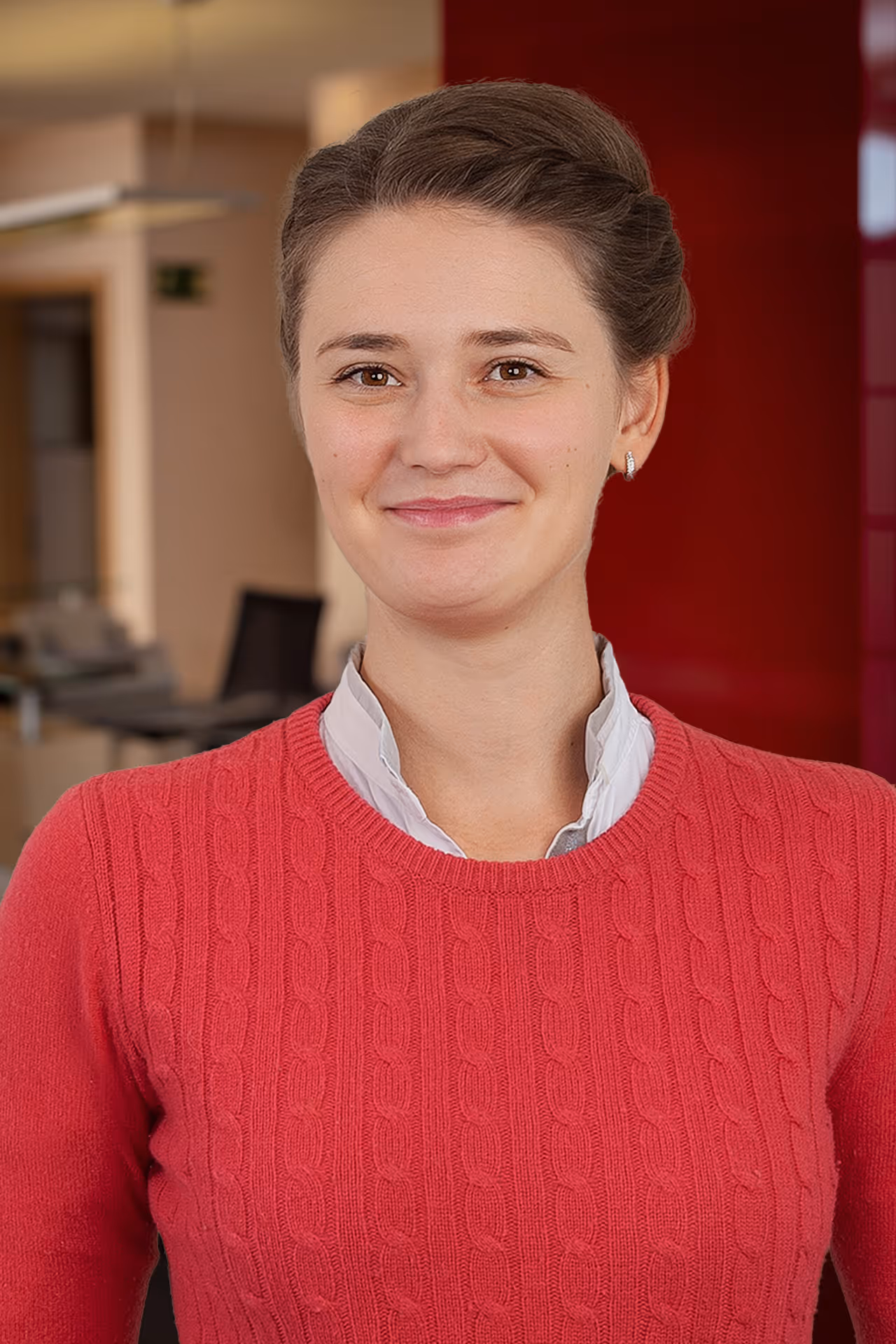 Portrait von Frau Dr. Greta Segbert mit hochgesteckten Haaren und rotem Pullover, die freundlich in die Kamera lächelt.