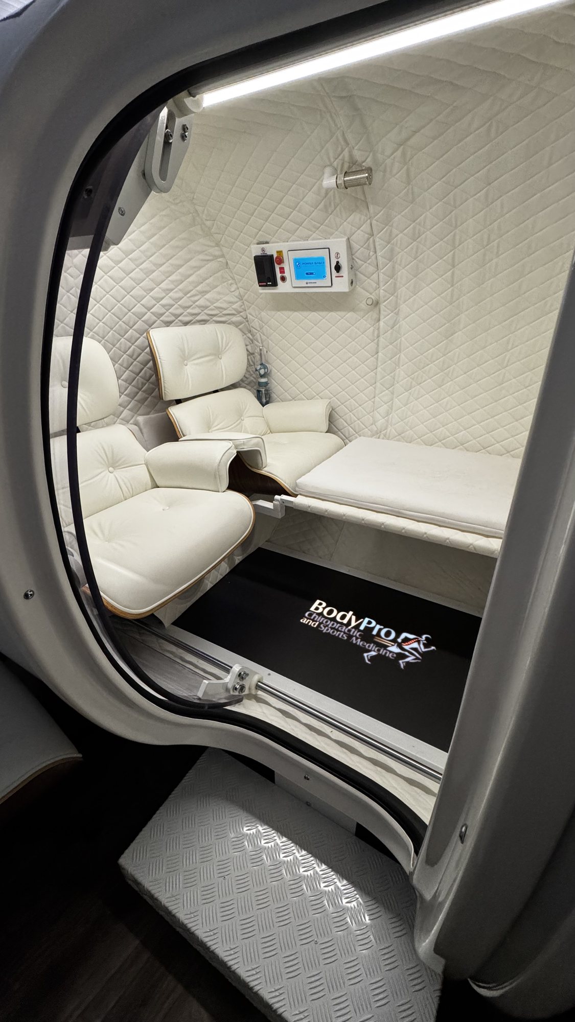 Private two-person suite with lounge seating inside BodyPro's hyperbaric oxygen chamber