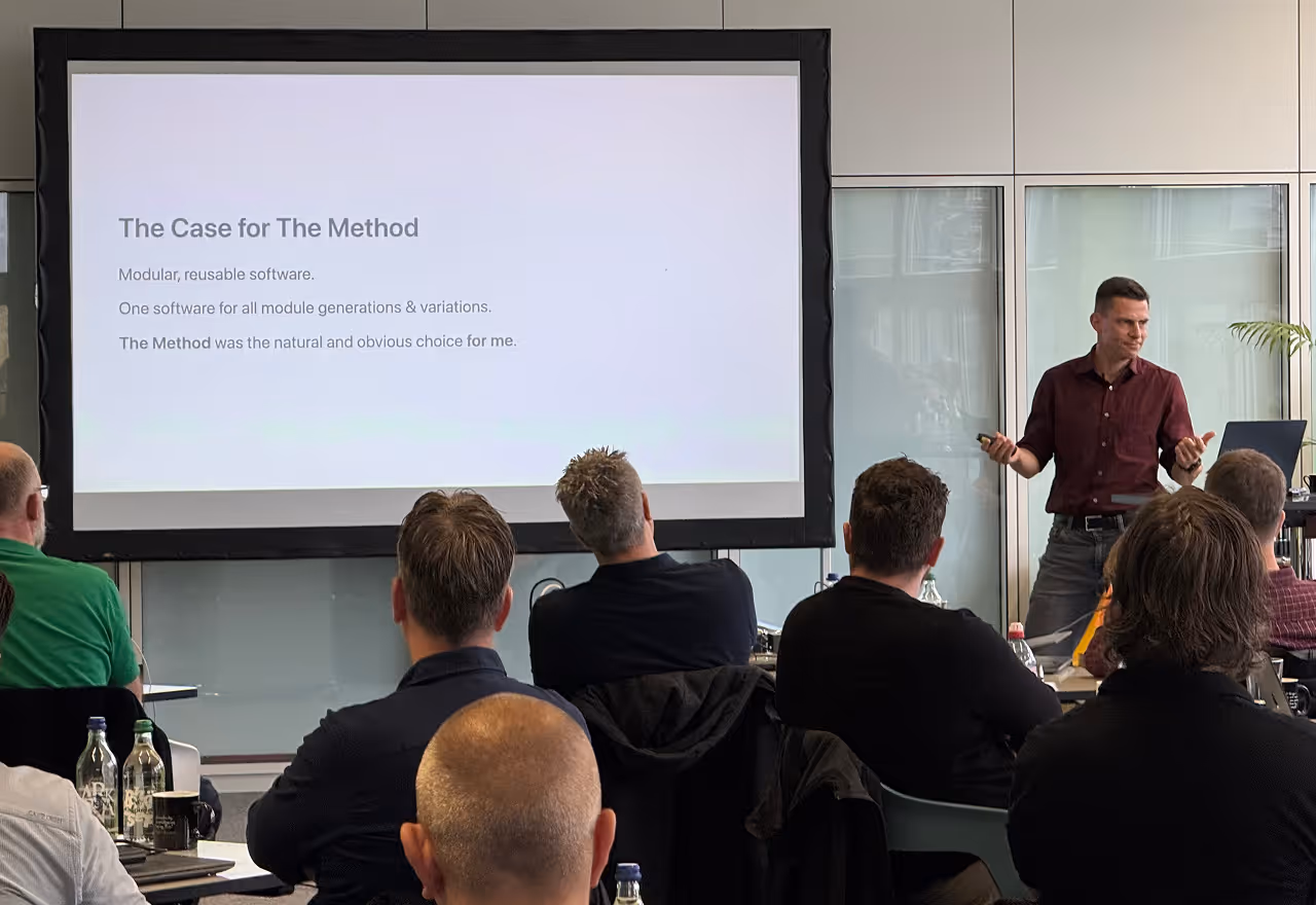 Man in maroon shirt giving a presentation to a group with a slide titled 'The Case for The Method'.