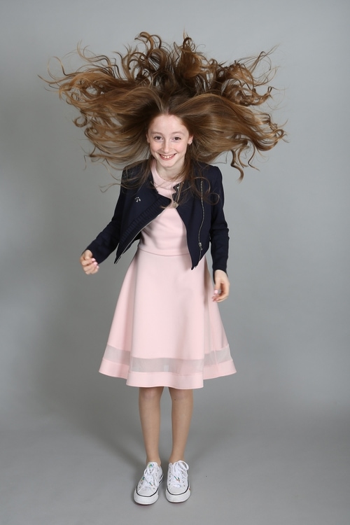 Confirmation girl flicking her hair by Jenny Callanan Photography