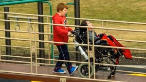 kid pushing a wheelchair 