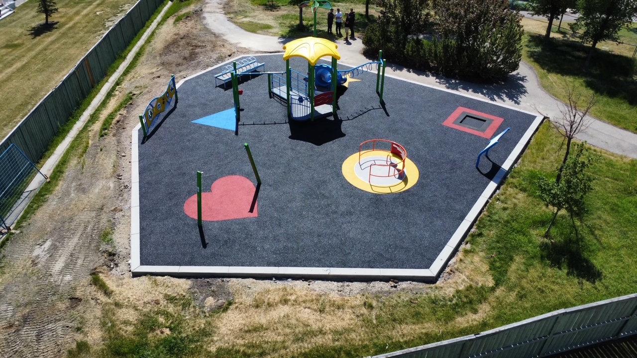 Bayside Rise inclusive playground in Airdrie showing accessible play equipment and rubber surfacing