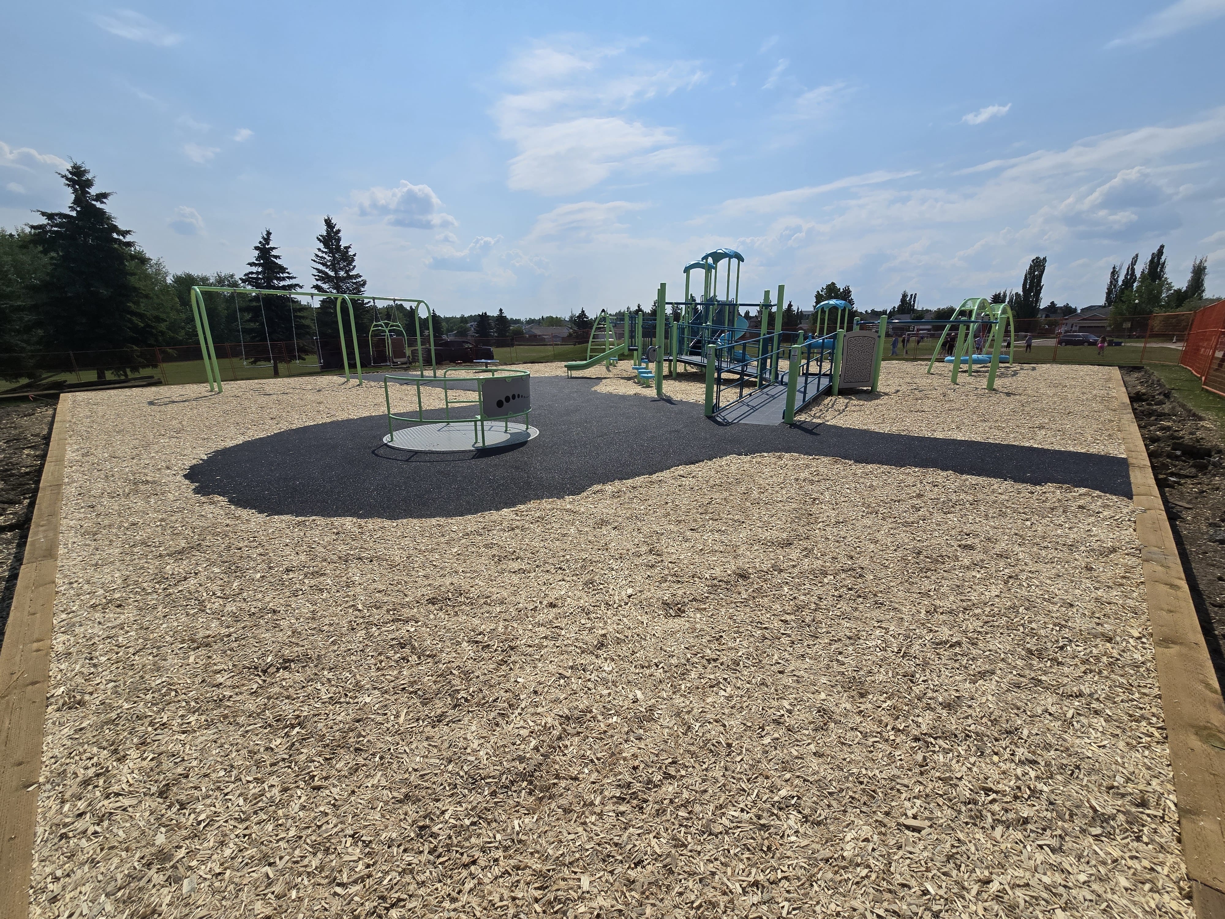 Steffie Woima Elementary School playground equipment in Sylvan Lake, AB with natural and built play elements