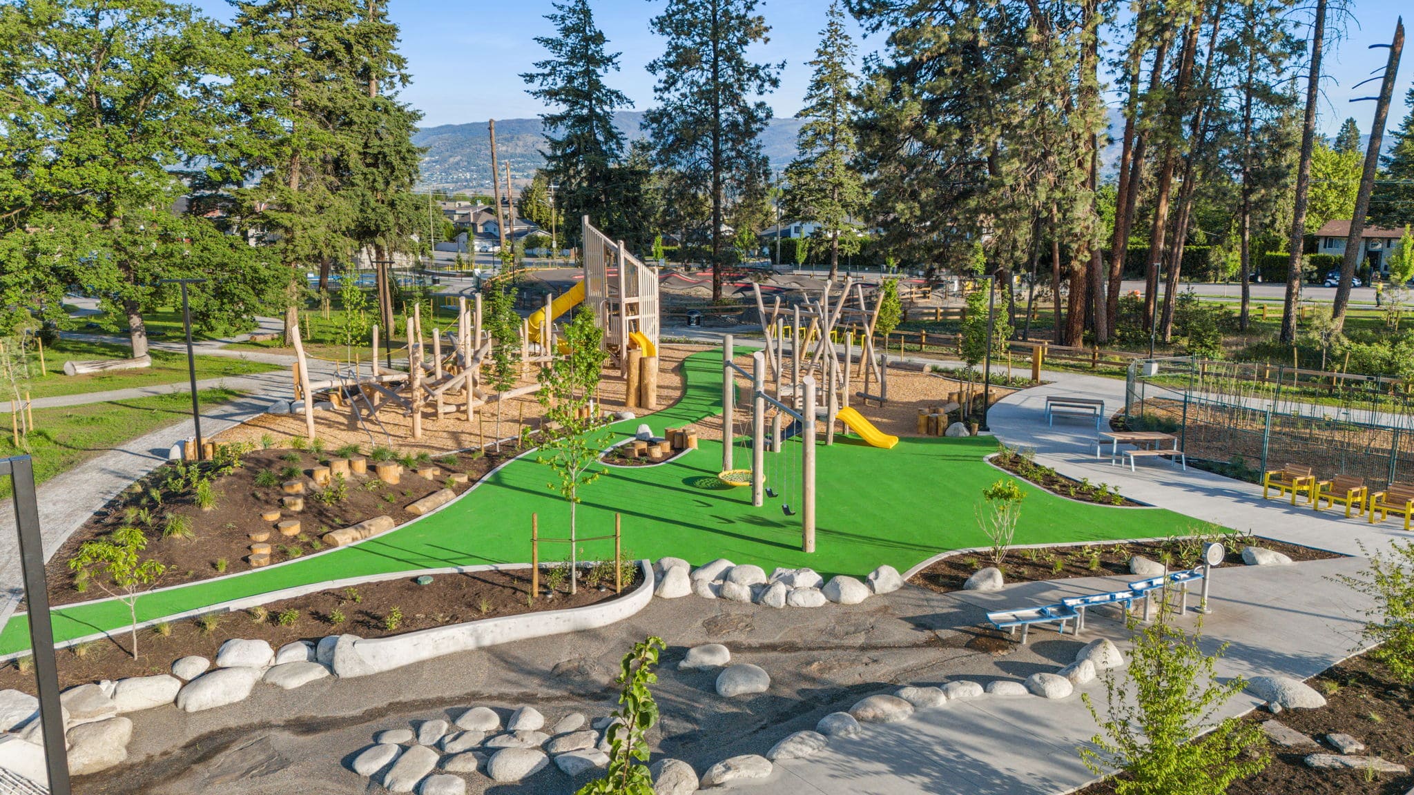 DeHart Community Park playground equipment in Kelowna, BC with climbing and sliding features