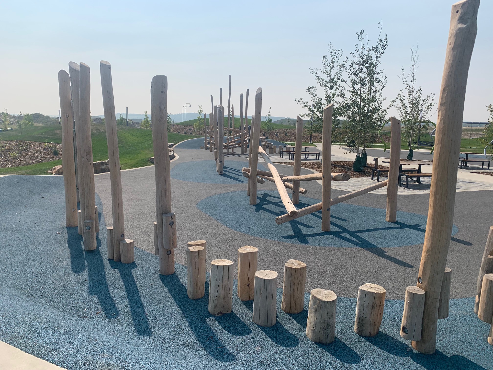 Yorkville Central Park playground equipment in Calgary, AB showing swing sets and climbing areas
