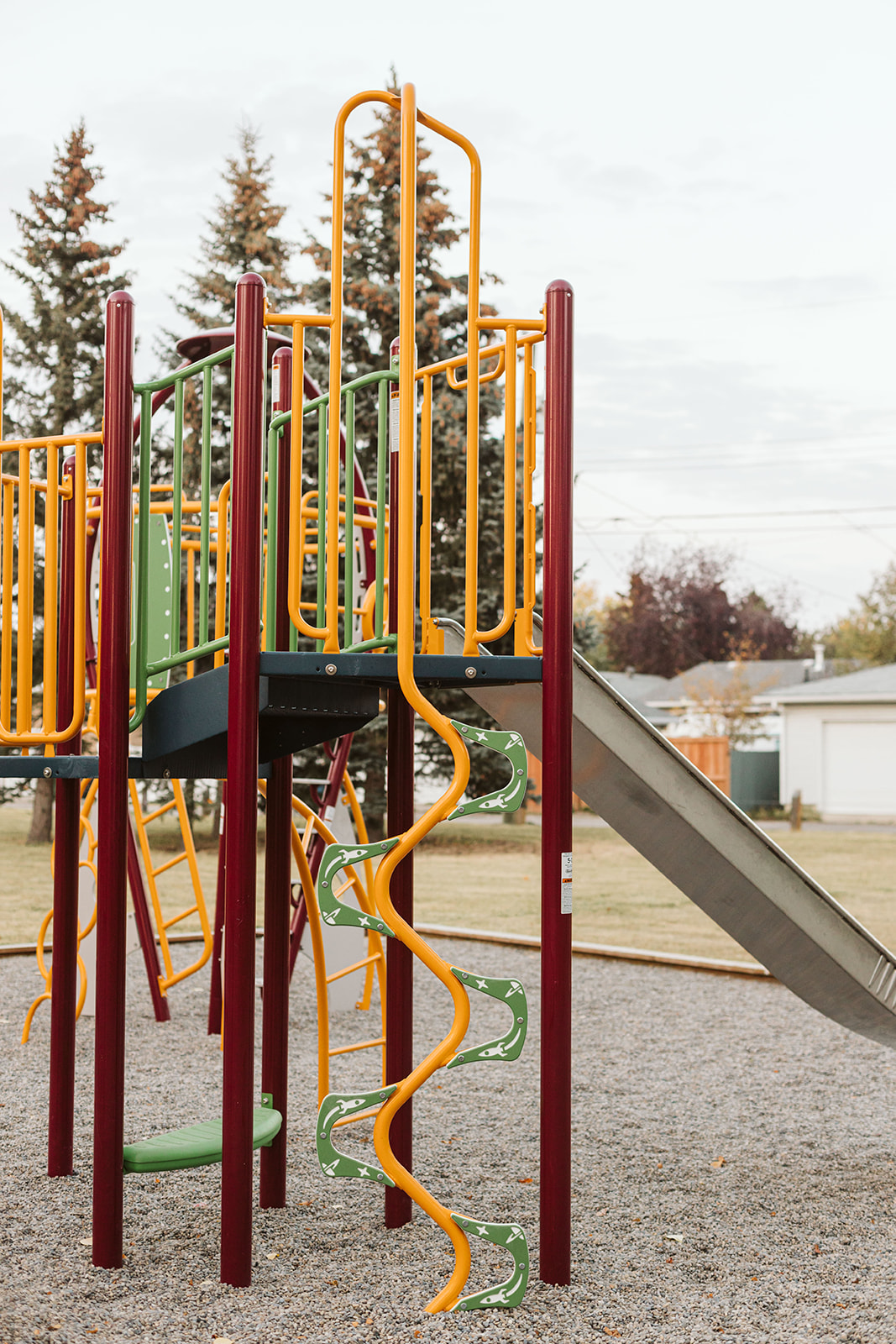 Marchand Park playground equipment in Calgary, AB featuring slides and activity panels
