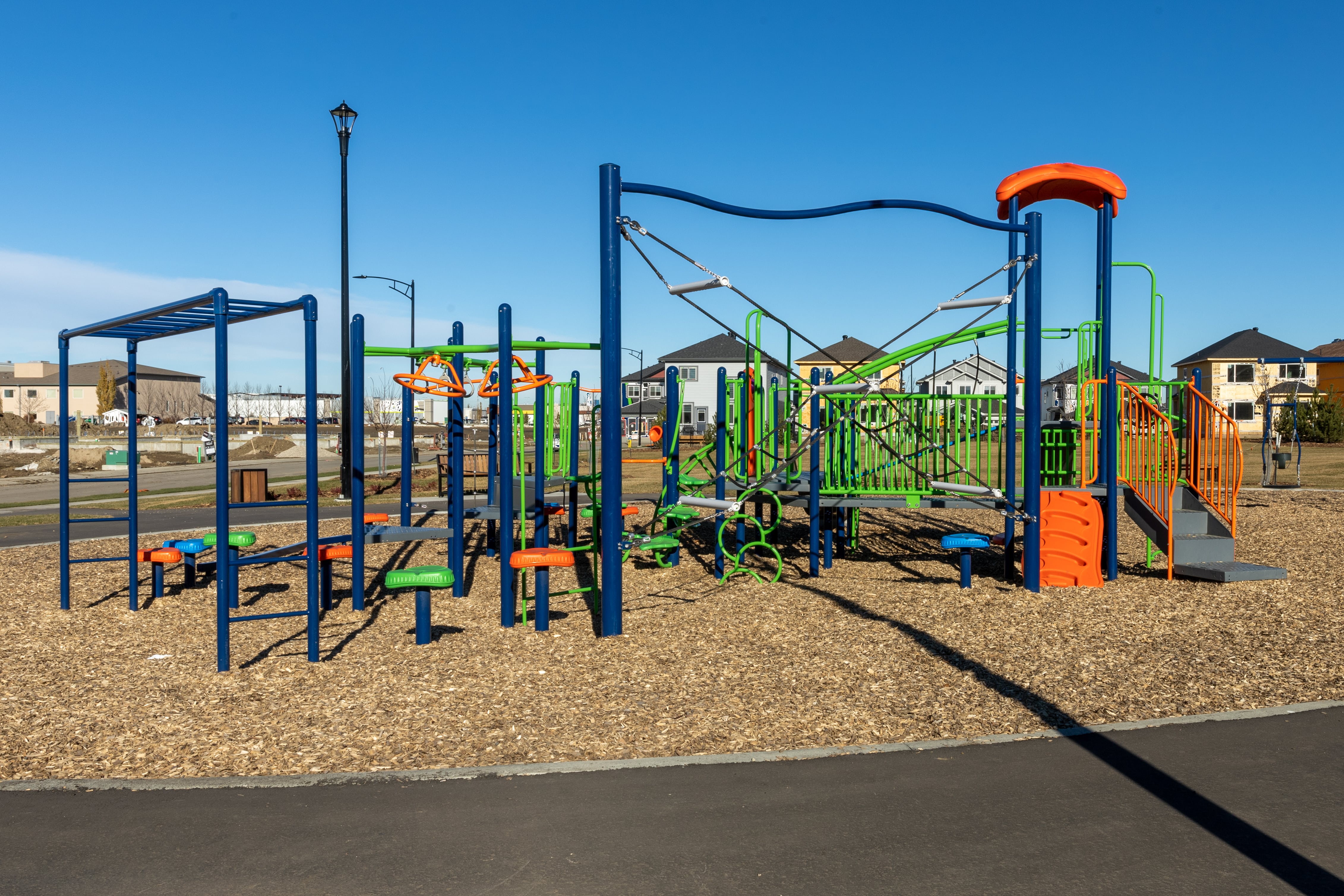 Aster Community Playground playground equipment in Edmonton, AB featuring colorful play structures