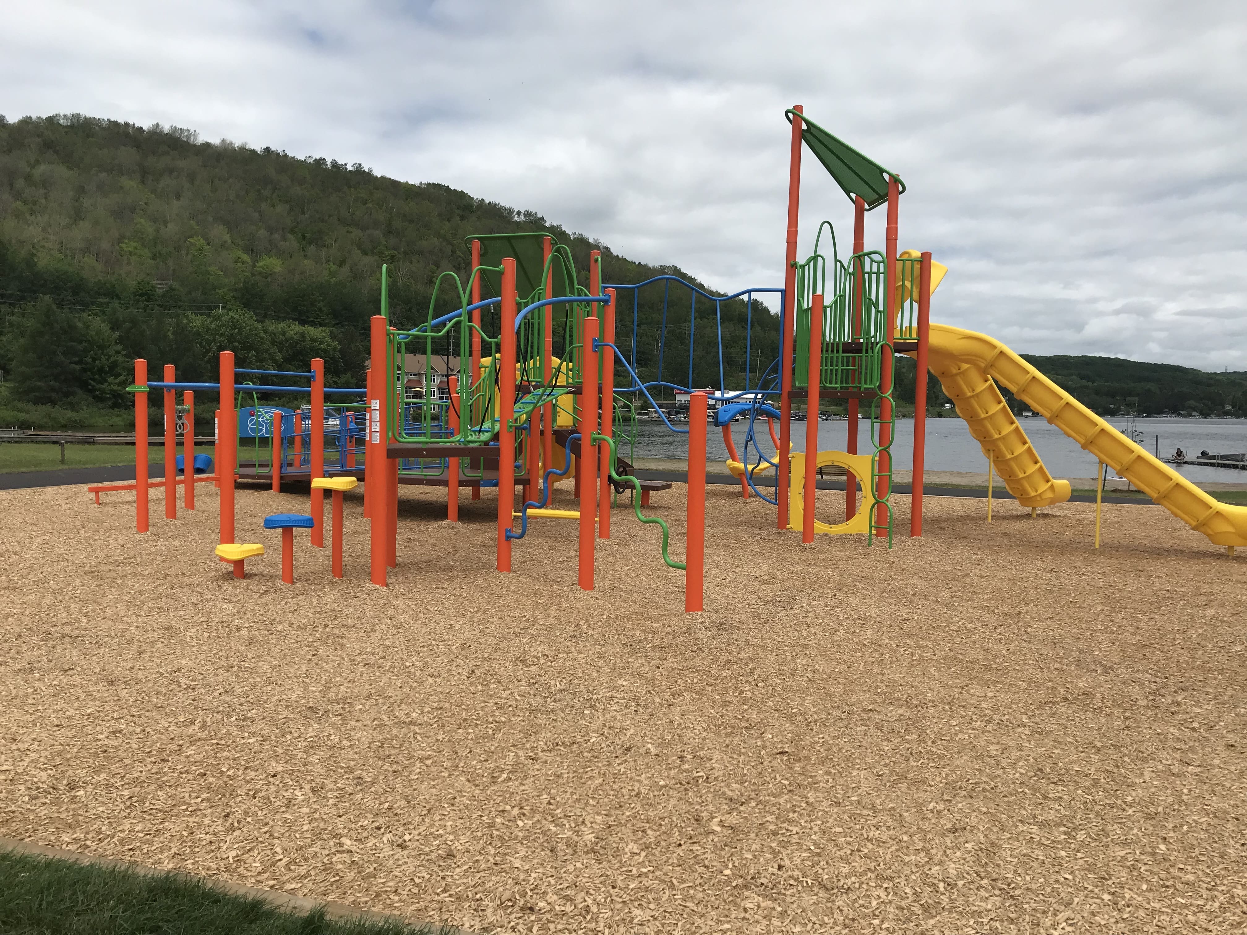 Olmstead Beach playground equipment in North Bay, ON featuring slides and activity panels