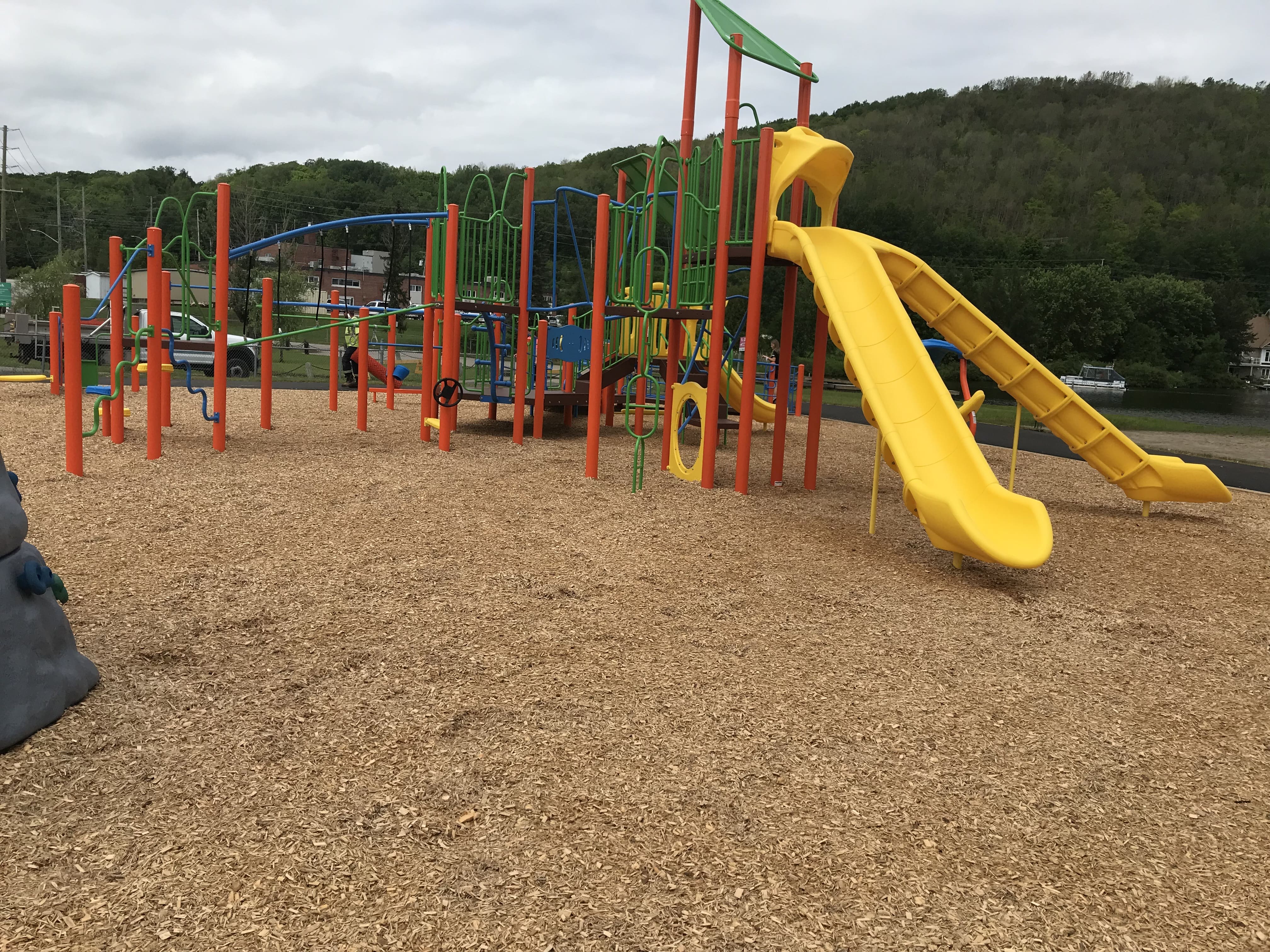 Olmstead Beach playground equipment in North Bay, ON showing swing sets and climbing areas