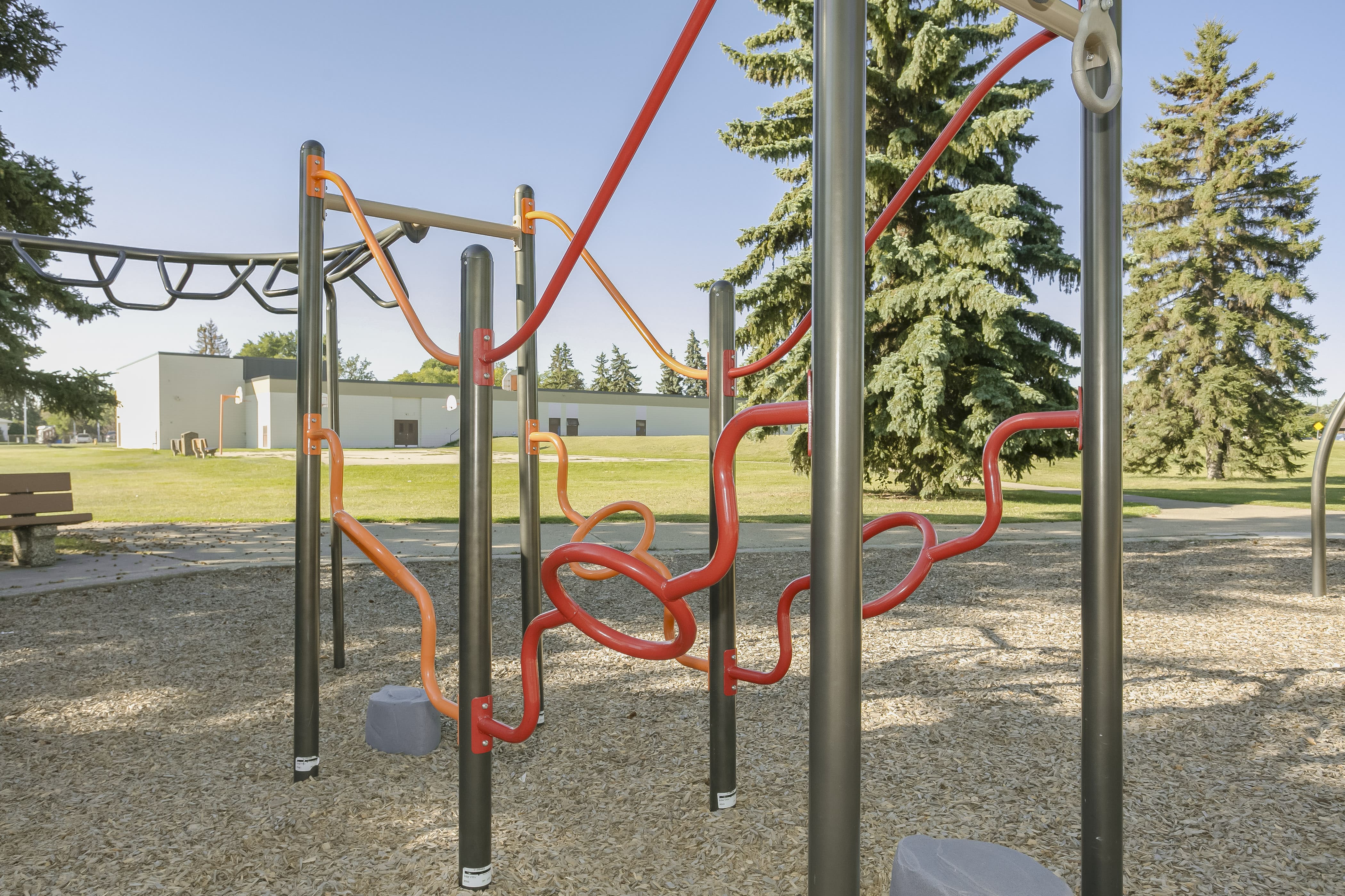 Rundle Heights Community Playground playground equipment in Edmonton, AB showing vibrant green orange blue colors