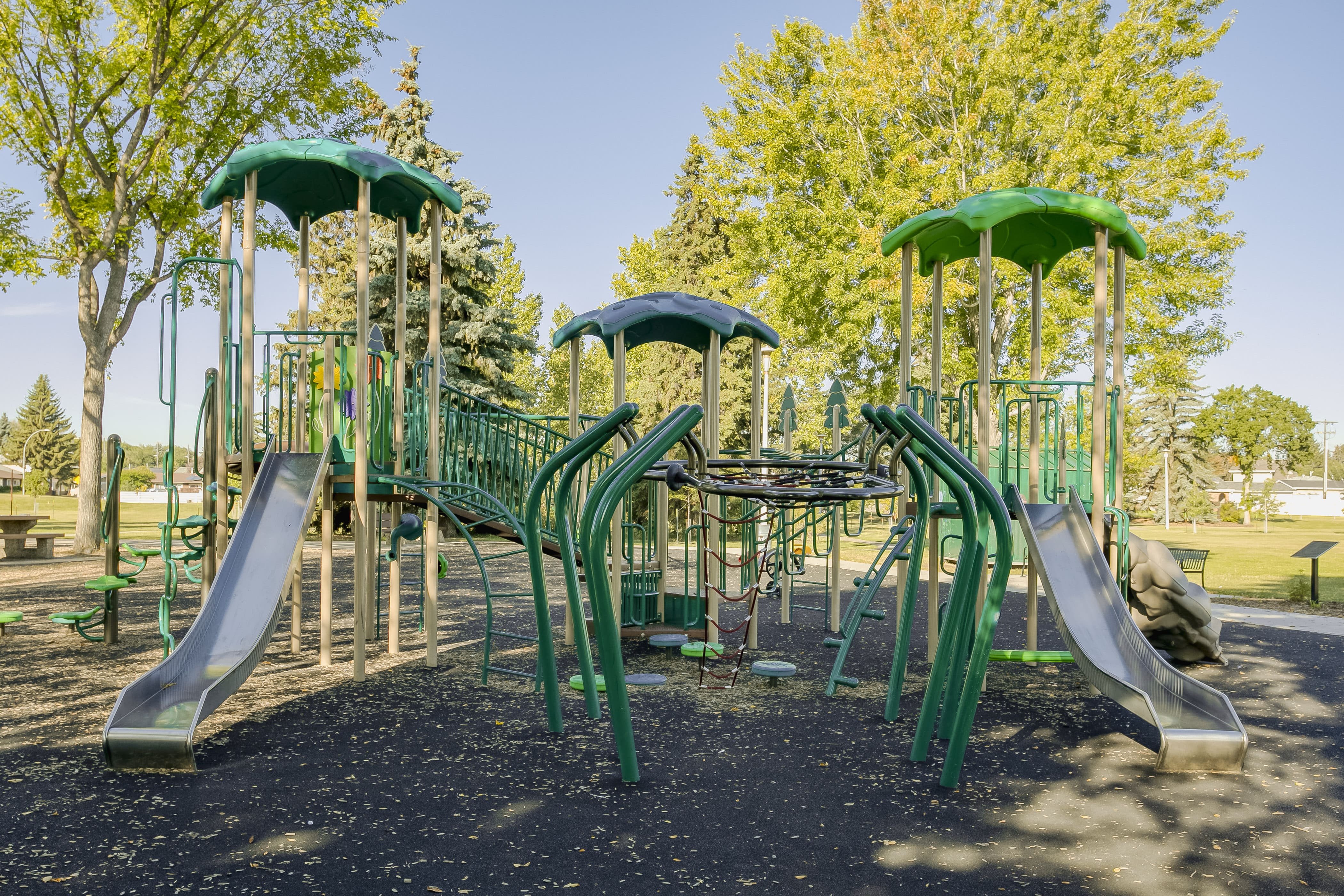 Rundle Heights Community Playground playground equipment in Edmonton, AB featuring slides and activity panels