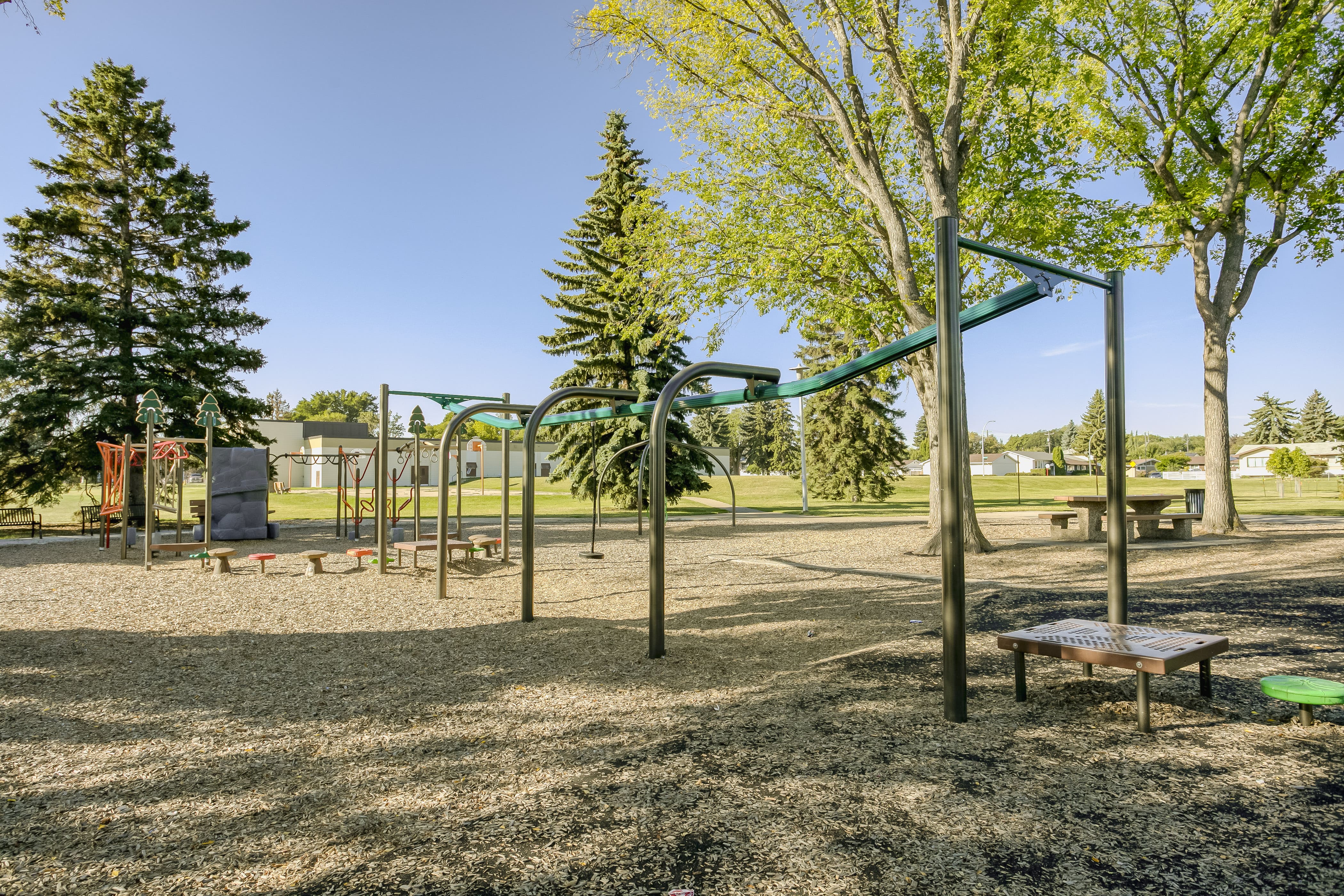 Rundle Heights Community Playground playground equipment in Edmonton, AB featuring colorful play structures