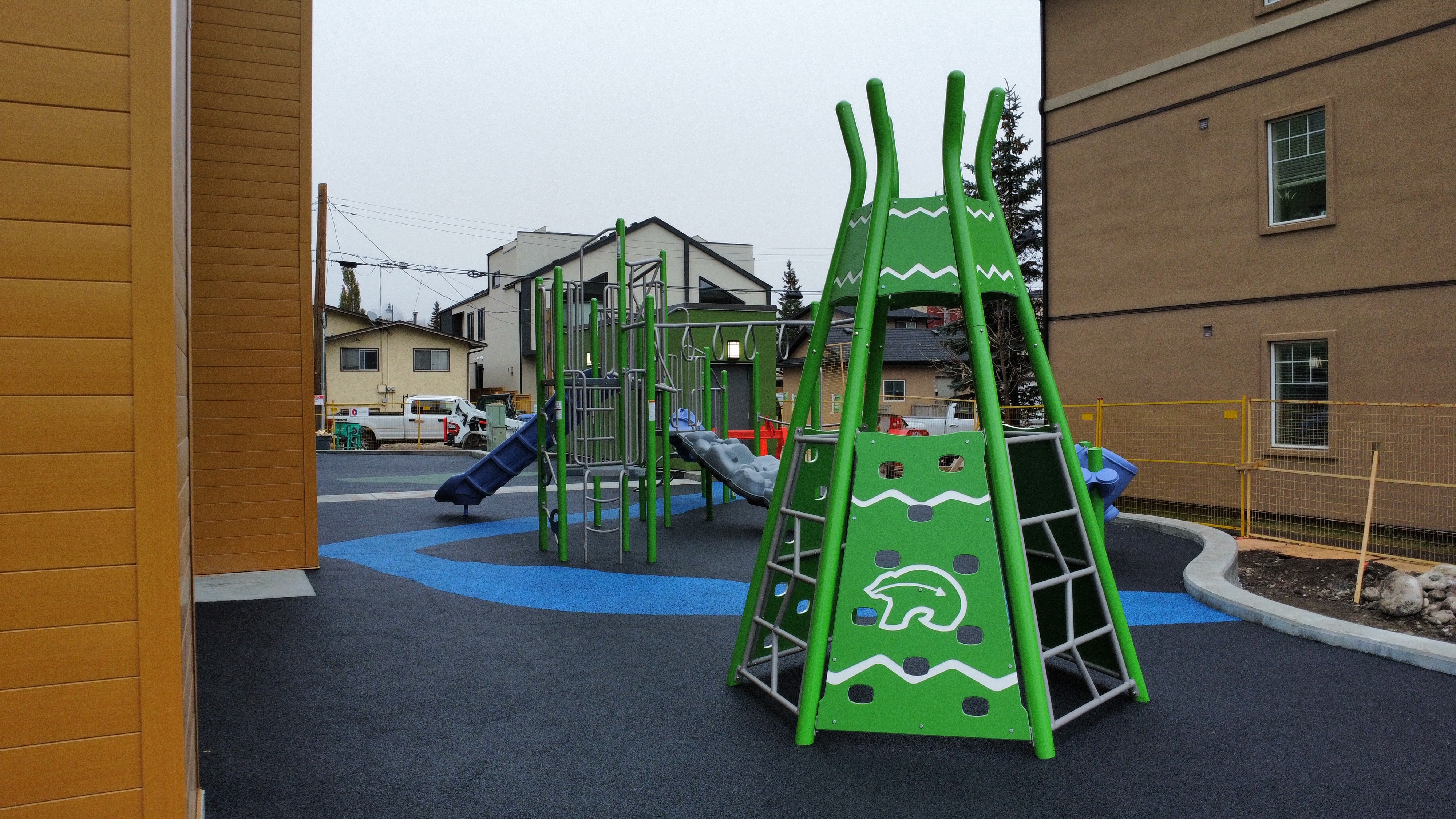 Children's Cottage Society playground equipment in Calgary, AB with safety surfacing and equipment