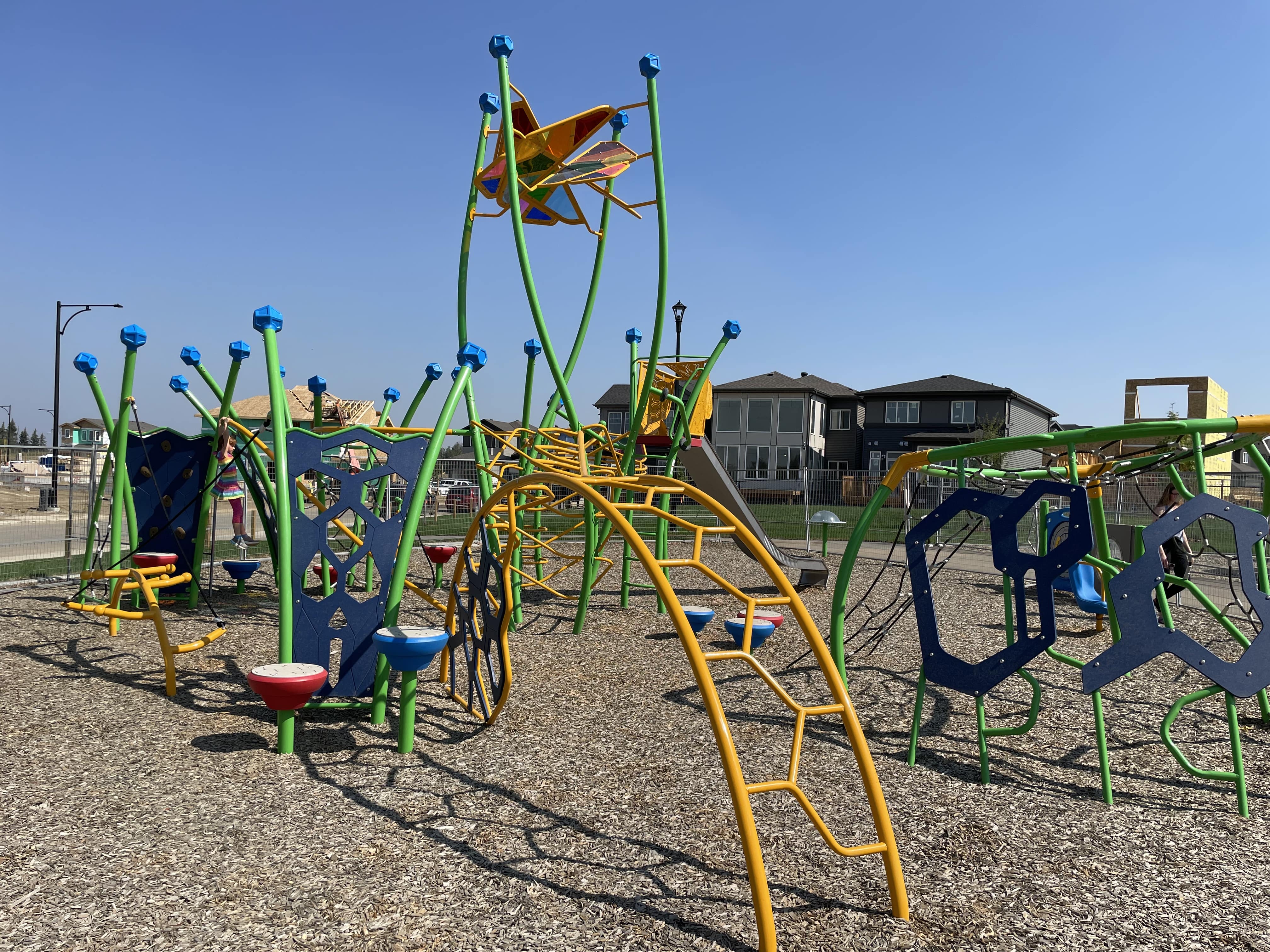 Kinglet Gardens playground in Edmonton, AB with rainbow stained glass star, unique climbers, xylophone flowers