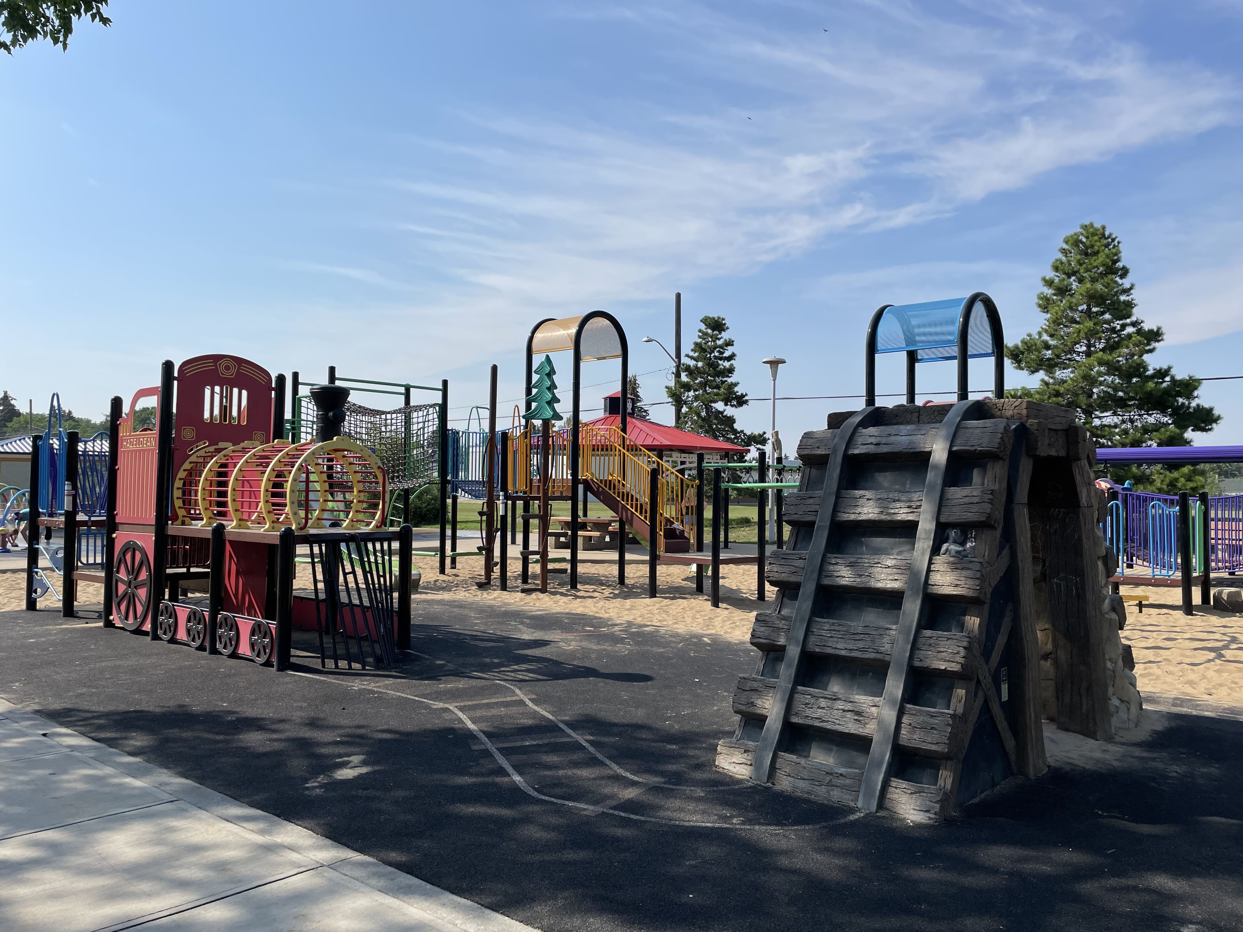Hazeldean Park playground equipment in Edmonton, AB showing rainbow colored train cars