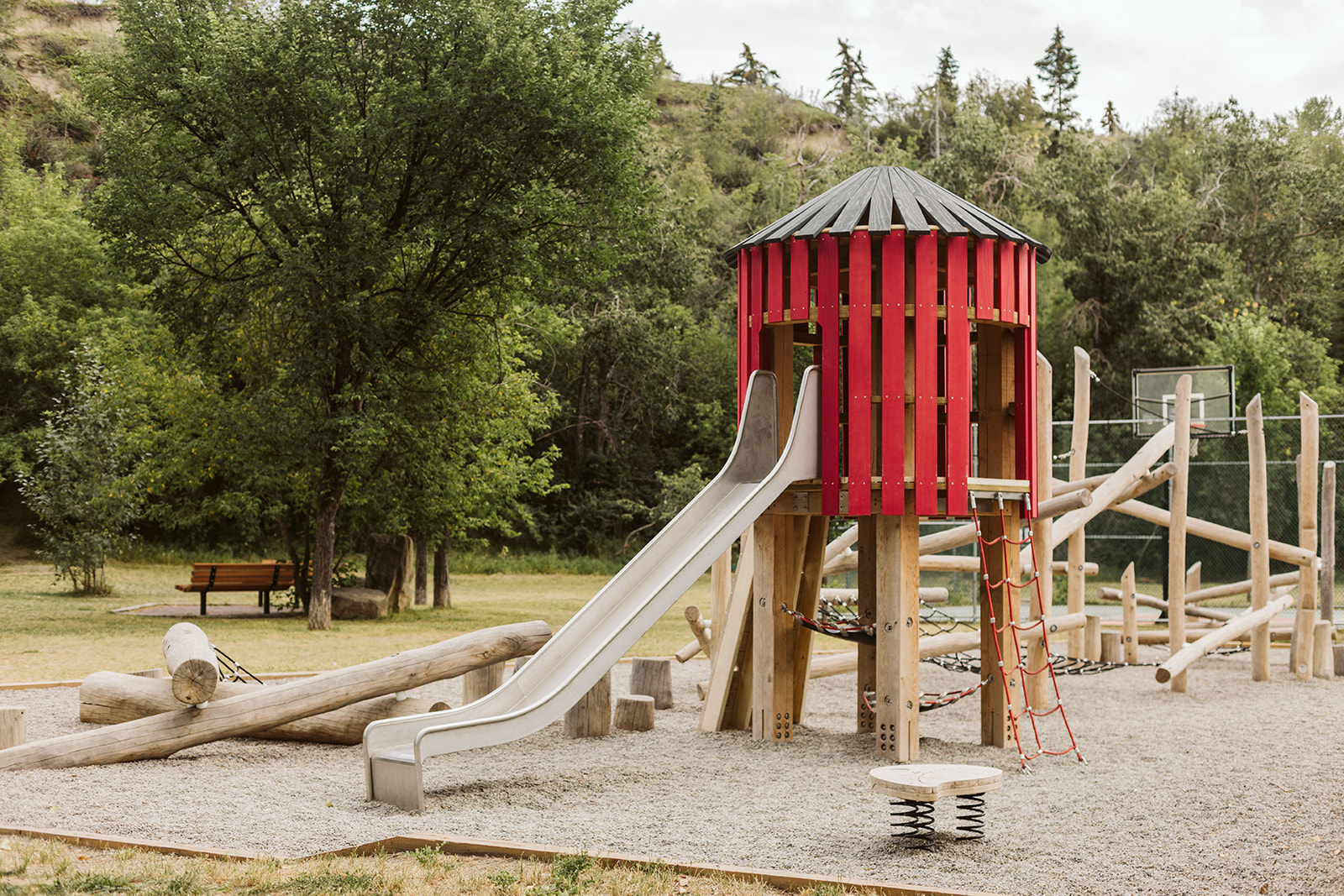 Rideau Roxboro Natural Community Playground in Calgary, AB featuring playground equipment with natural community playgroun...