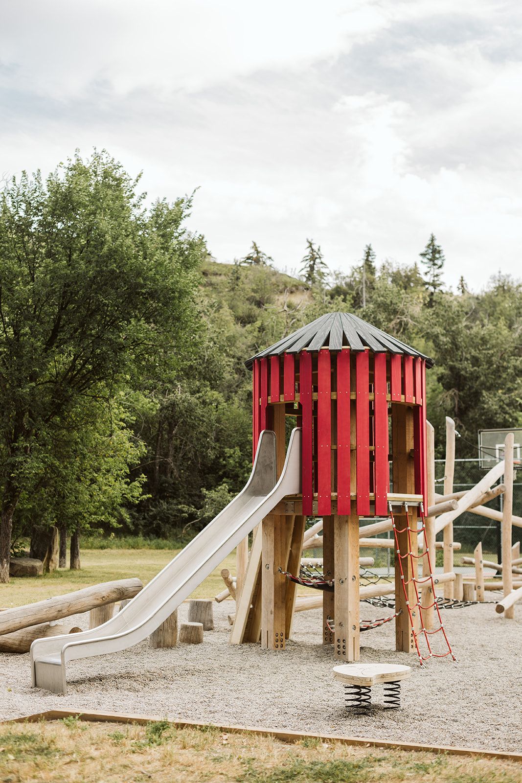 Rideau Roxboro Natural Community Playground playground equipment in Calgary, AB featuring Catholic school playground design