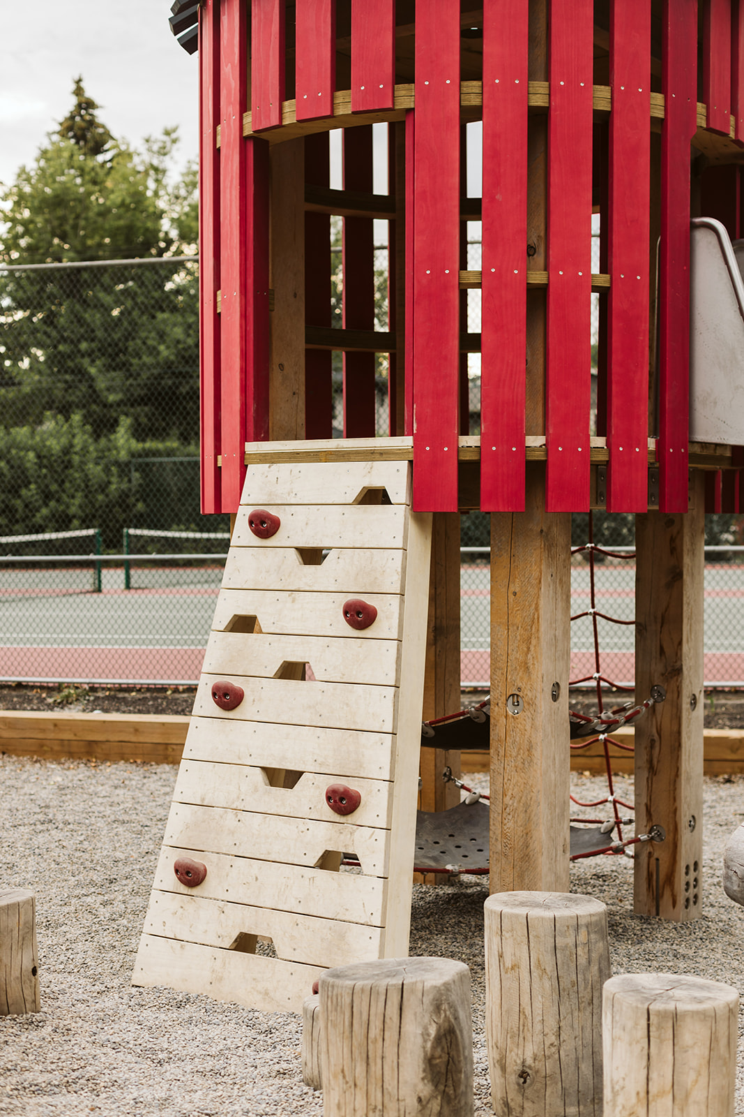 Rideau Roxboro Natural Community Playground playground equipment in Calgary, AB showing lush greenspace integration