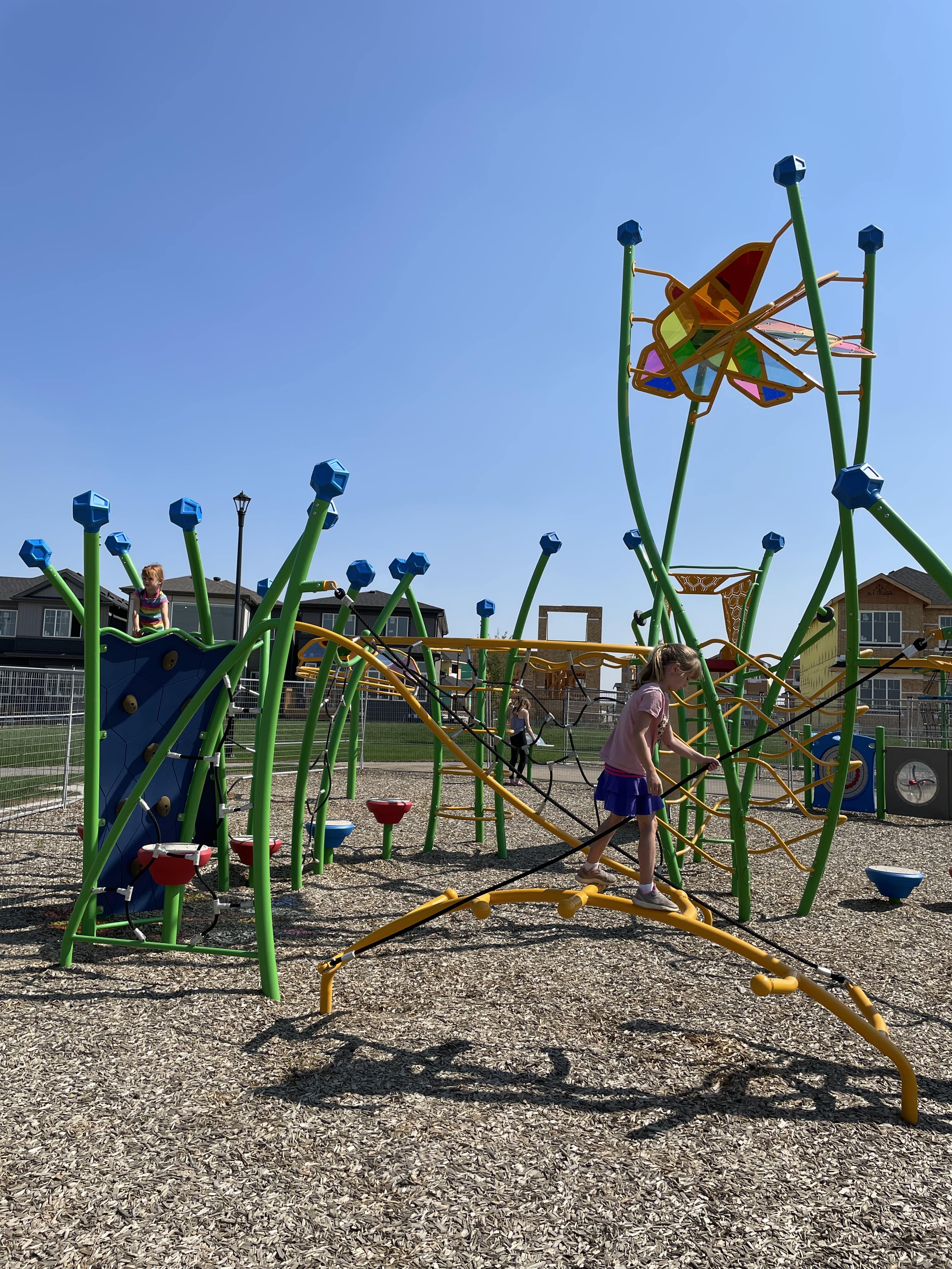 Kinglet Gardens (Edmonton, AB) playground in Edmonton, AB - children playing on equipment