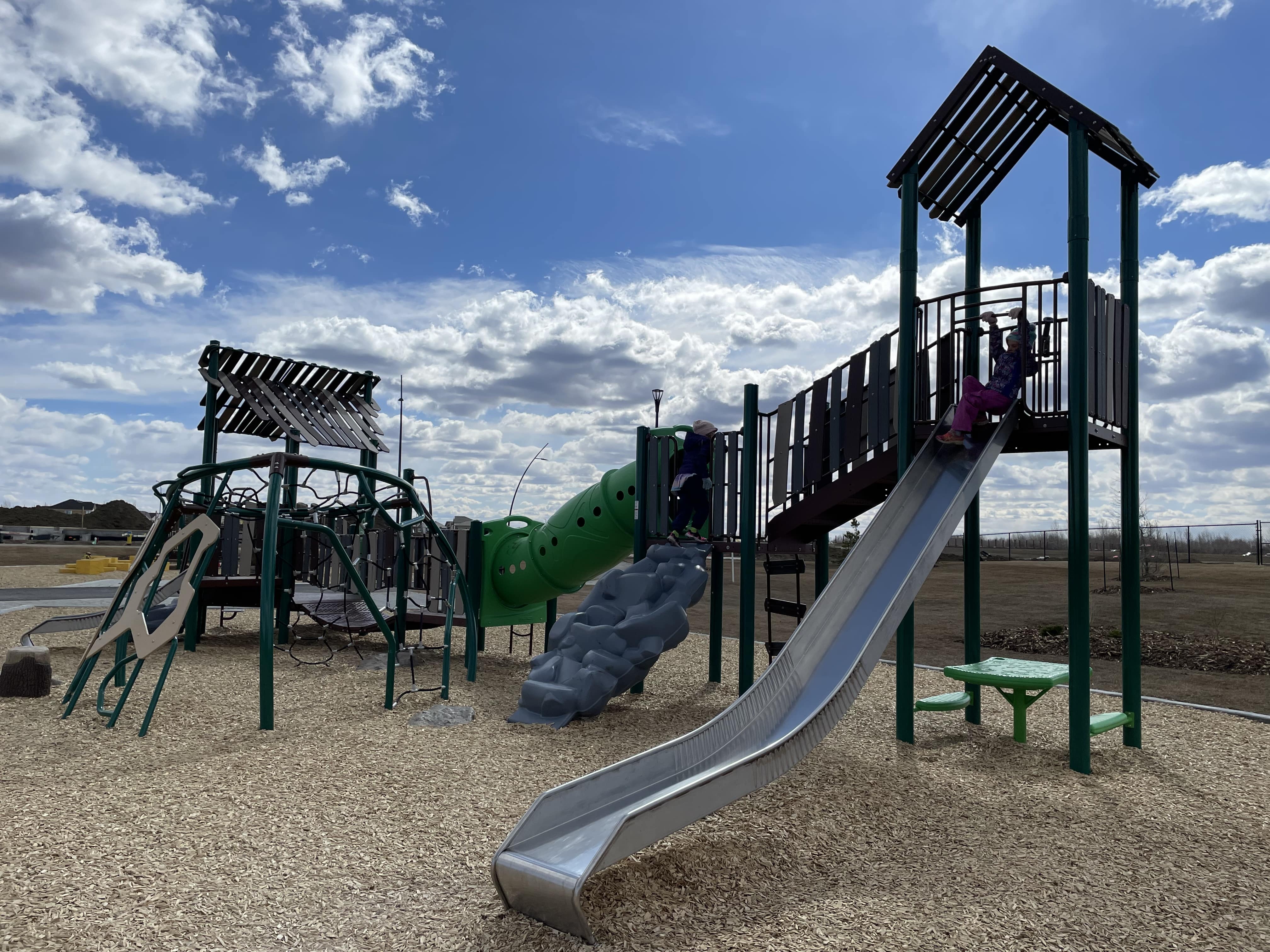 Uplands Playground (Edmonton, AB) playground in Edmonton, AB - children playing on equipment