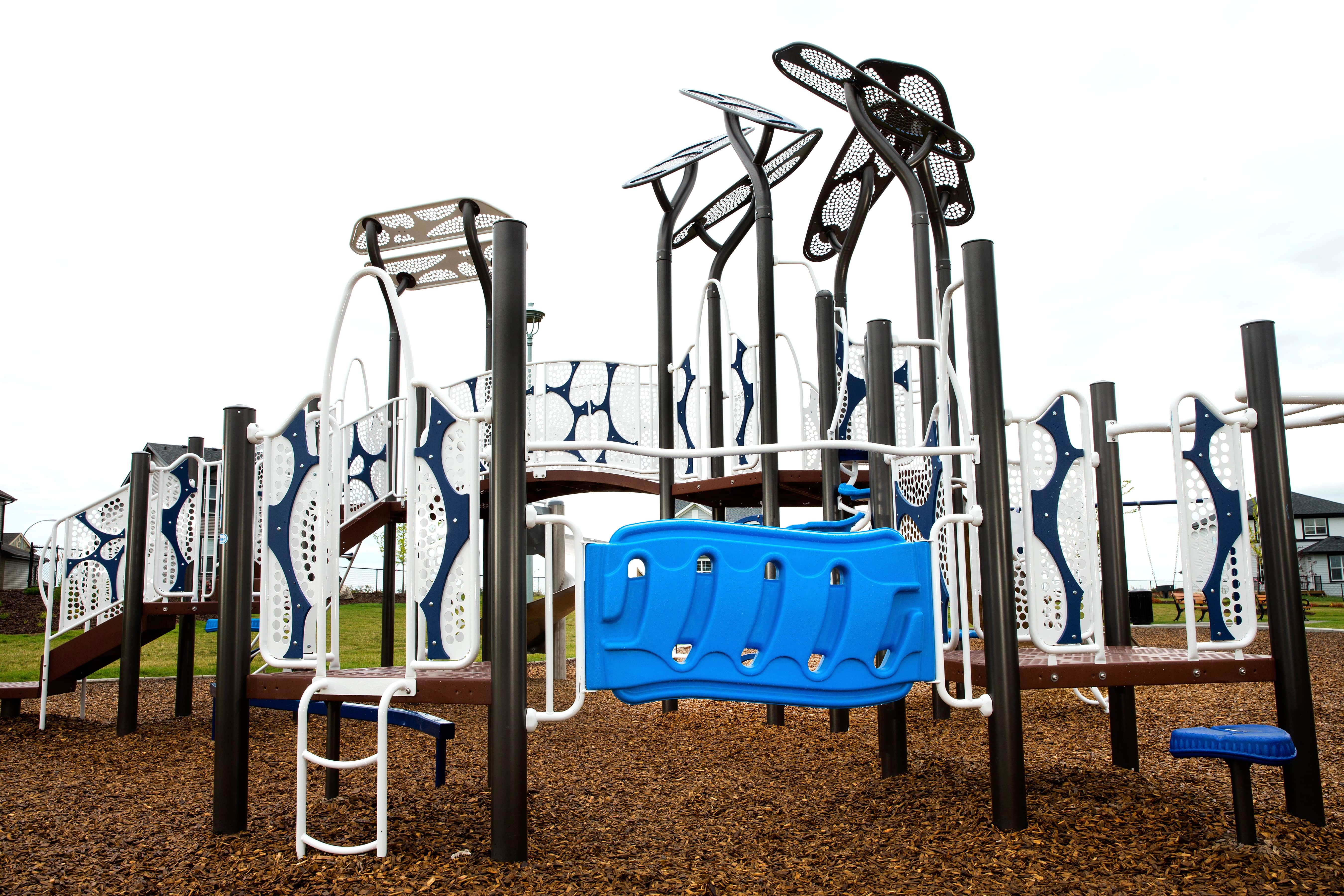 McConachie Subdivision (Edmonton, AB) playground in Edmonton, AB - children playing on equipment