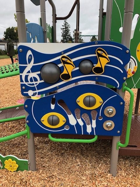 Blue music panels with wavy white lines, black round play drums, yellow musical-note graphics and two silver bells.