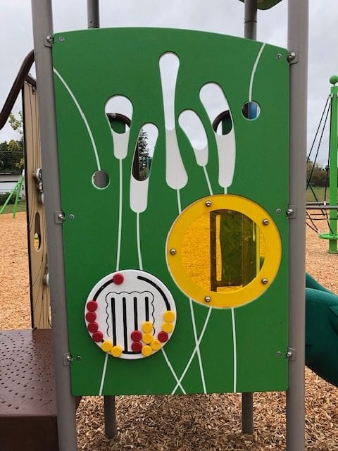 Green activity panel with white reed motifs, yellow circular window and rotating bead-count disc with red and yellow beads.