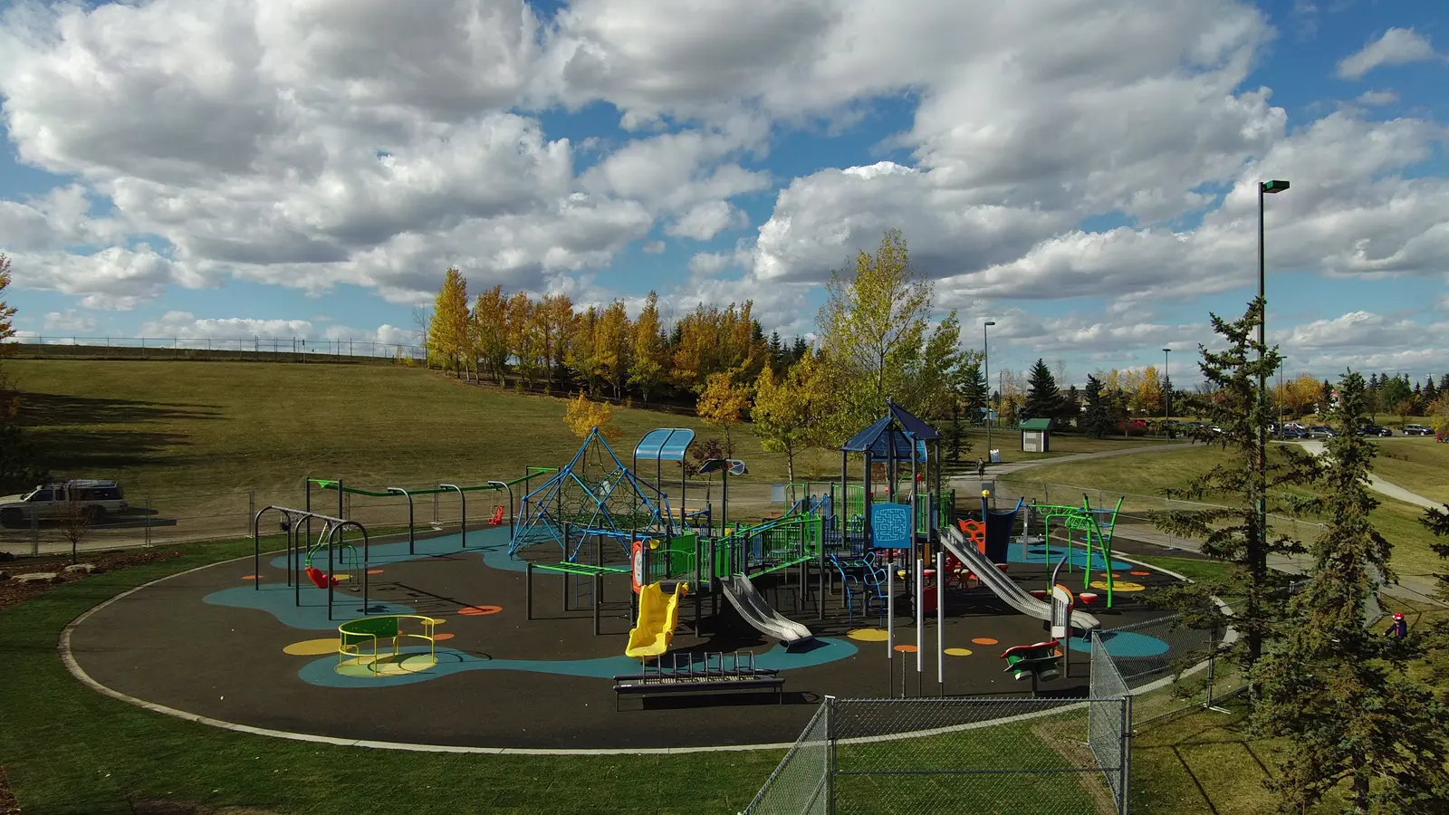Aerial view of Elliston Park playground: net climber, shade-roofed towers and slides on blue and black poured-in-place rubber