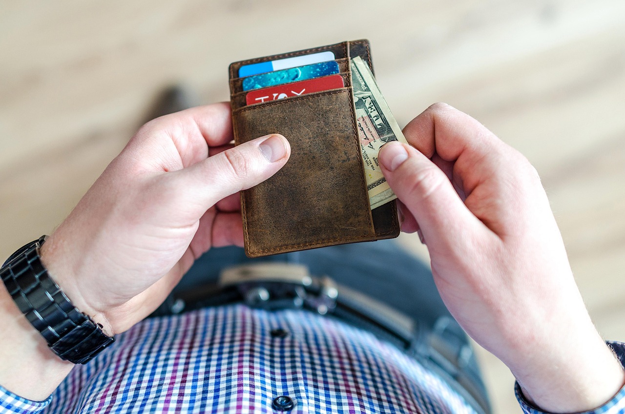 man pulls cash out of wallet