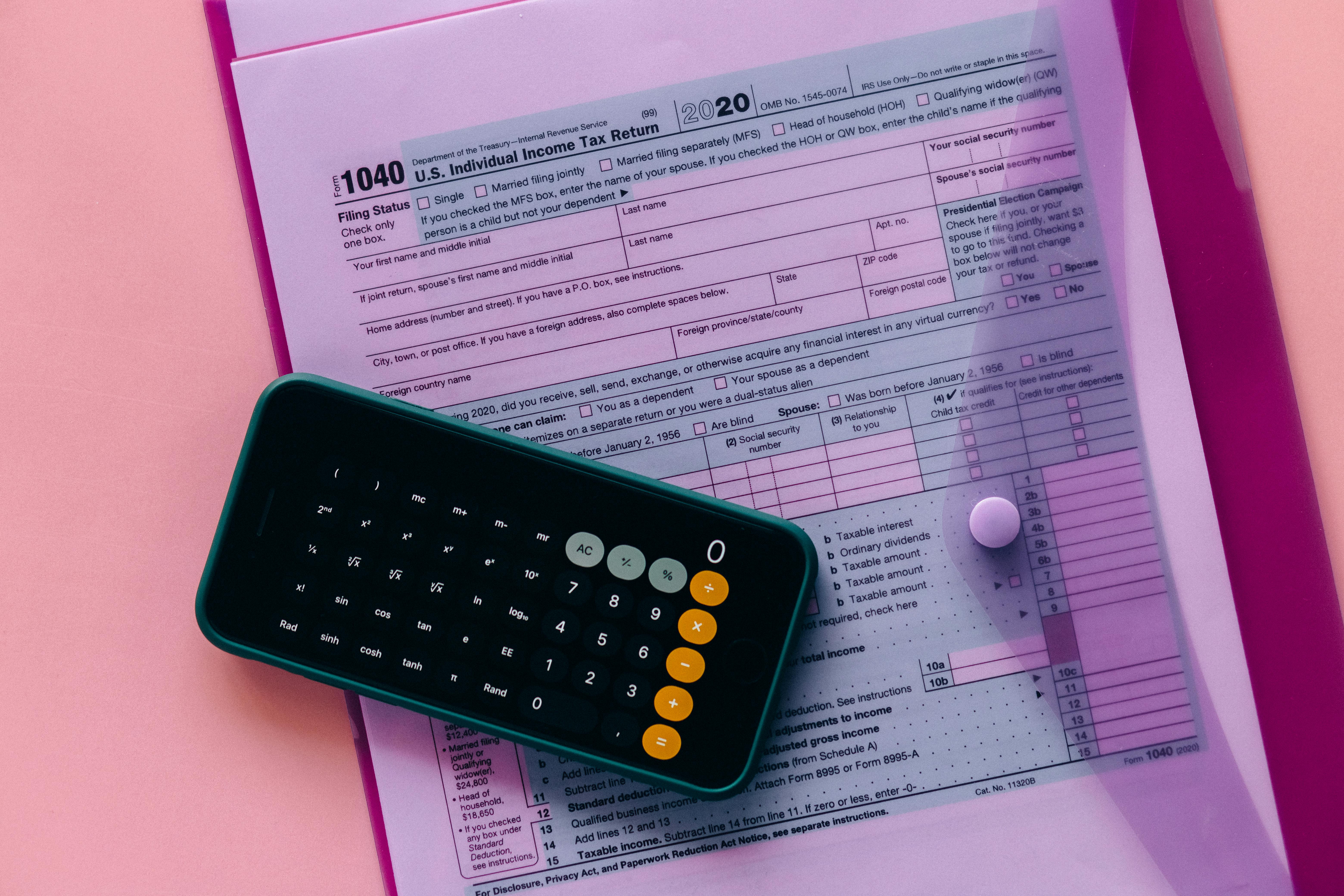 Calculator resting on a completed U.S. Individual Income Tax Return (Form 1040), suggesting income and tax calculations.