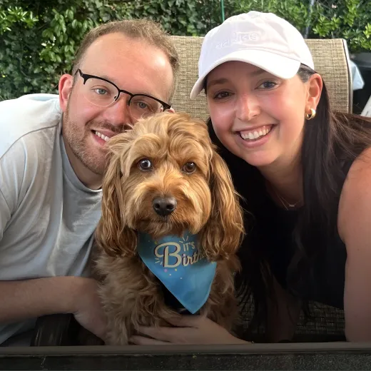 Enzo the dog posing patiently with their pet parents.