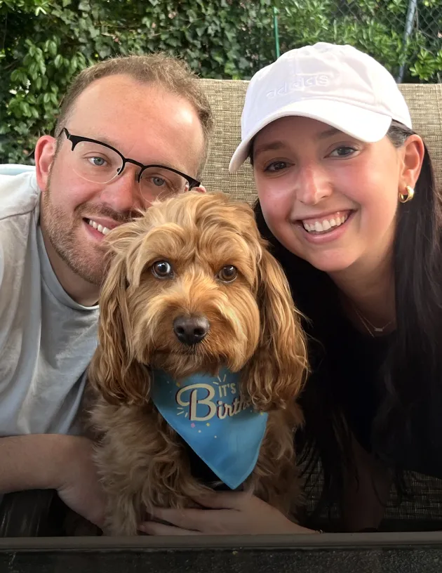 Enzo the dog posing patiently with their pet parents.