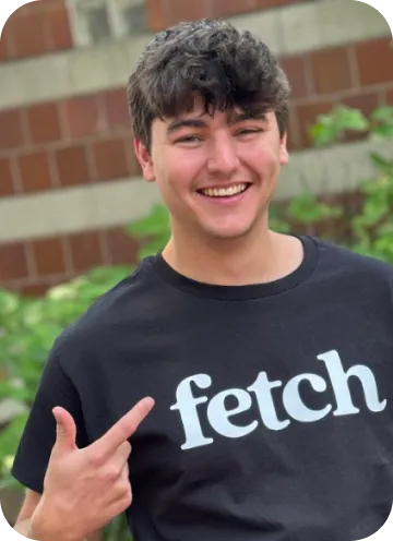 A Fetch intern pointing at the logo on their shirt.
