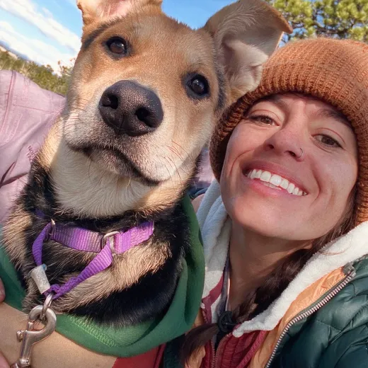 A Fetch employee posing with their dog.