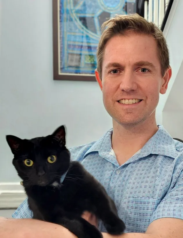 A Fetch employee holding their cat.