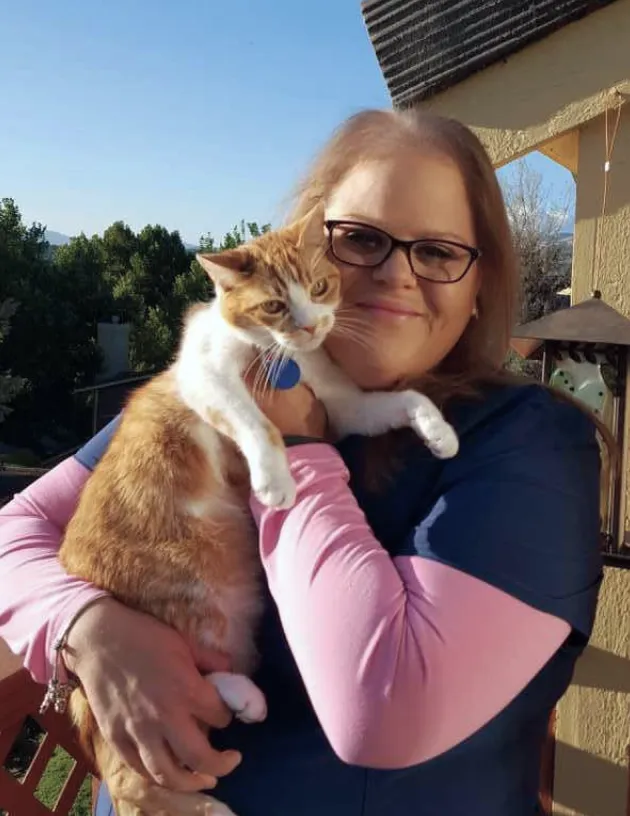 A Fetch employee holding their cat.