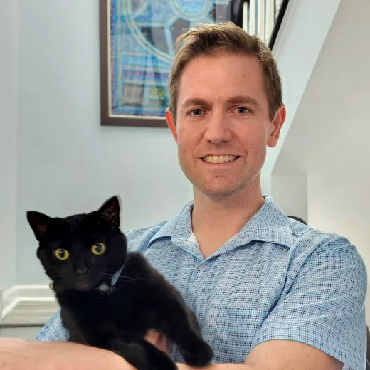 A Fetch employee holding their cat.