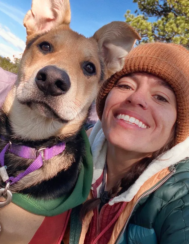 A Fetch employee posing with their dog.