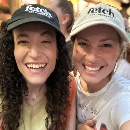 Two Fetch employees wearing Fetch hats.