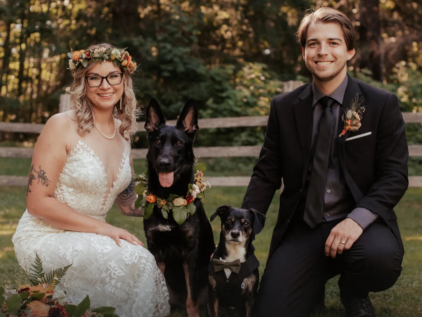 A bride and groom posing with their dogs on their wedding day.