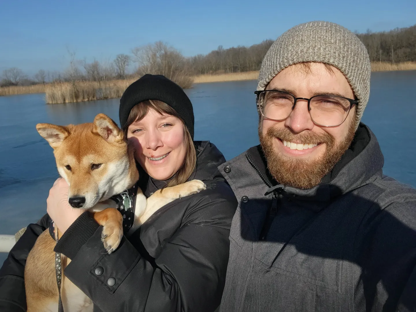 A couple posing with their dog.