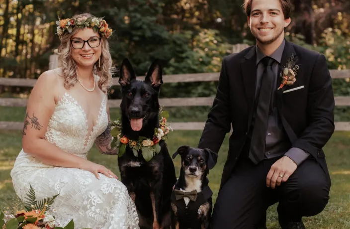 Ellie posing with pet parents on their wedding day.